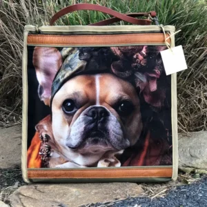 Custom brown tote bag featuring a detailed illustration of a dogs face, resting on a stone ledge with a leather shoulder strap.