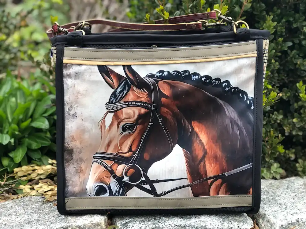 Custom black tote bag featuring a detailed illustration of a horse's head, resting on a stone ledge with a leather shoulder strap.