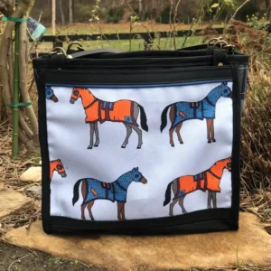 Custom black tote bag featuring a detailed illustration of horses wearing orange and blue coats, resting on a stone ledge with a leather shoulder strap.