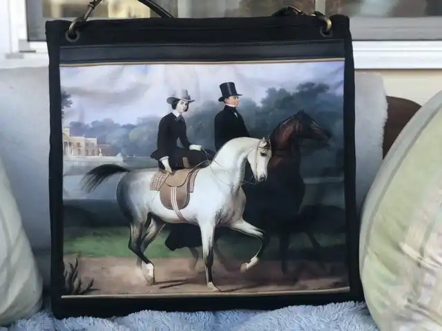 Custom tote bag featuring a detailed illustration of two horses and riders, with a leather shoulder strap.