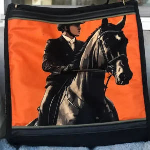 Custom black tote bag featuring a detailed illustration of a brown horse and rider, resting on a couch with a leather shoulder strap.